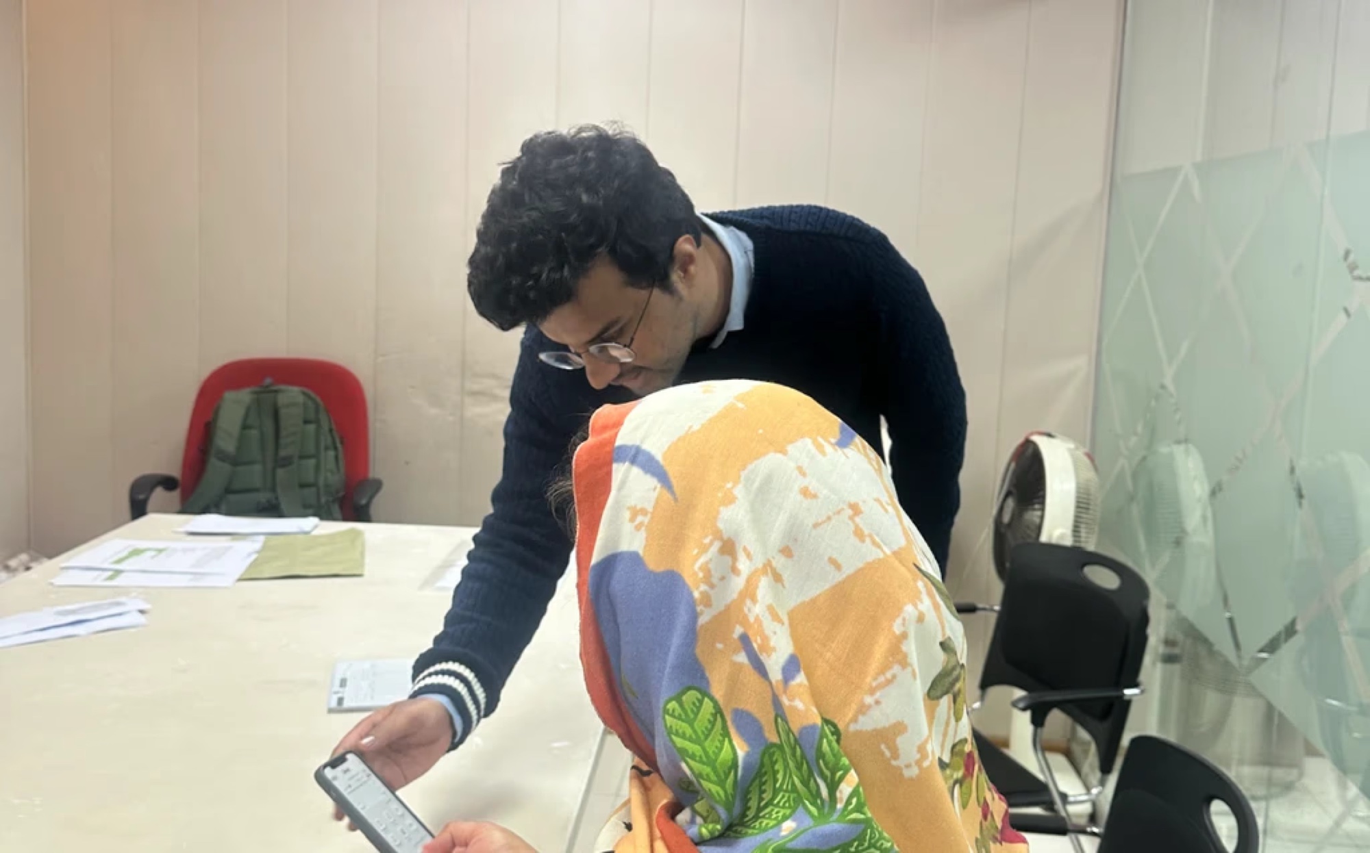 Field research session with a Dost customer, reviewing the app on a mobile phone.