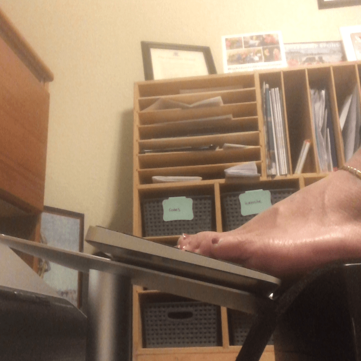 Jessica typing on her keyboard using her feet, toes resting on the home row.